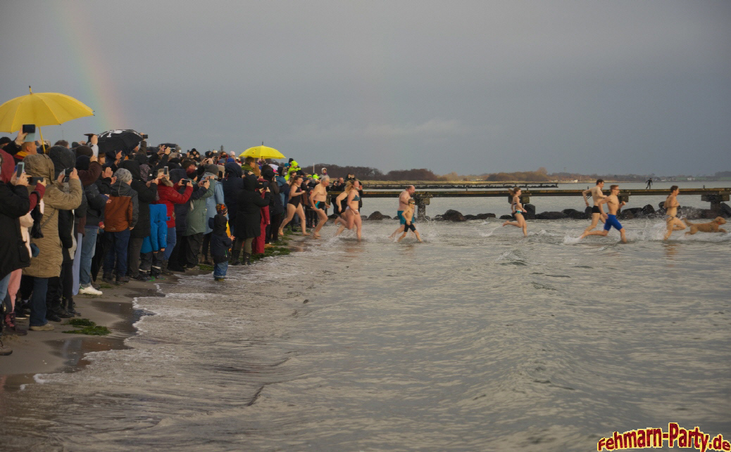 Viele Besucher schauen am Ostseestrand den Teilnehmern des Anbaden auf Fehmarn zu.